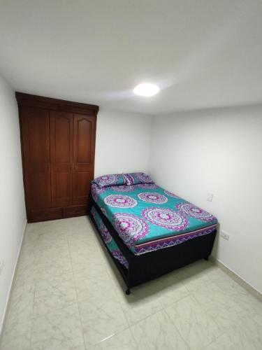 Ce petit lit se trouve dans un dortoir doté d'une porte en bois. dans l'établissement Apartamento con jacuzzi En Bello - Cerca a Medellín, à Bello