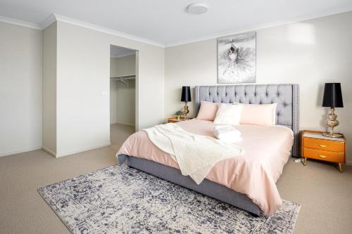 a bedroom with a large bed with a gray headboard at Spacious Villa 7BRM 5-bathroom House Point Cook Double Storey in Point Cook