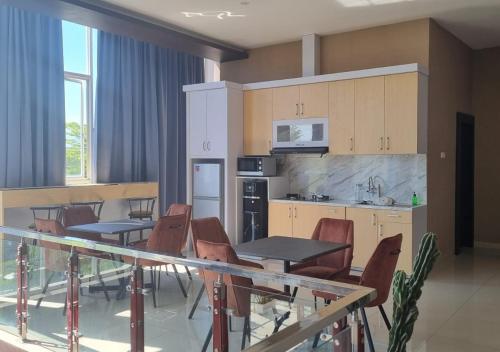 帕卢Hotel Kembang Joyo的厨房以及带桌椅的用餐室。