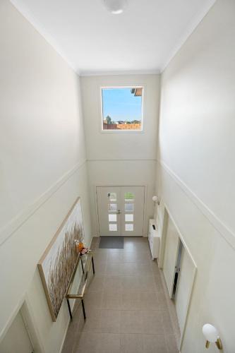 a white hallway with a staircase with a window at Spacious Villa 7BRM 5-bathroom House Point Cook Double Storey in Point Cook