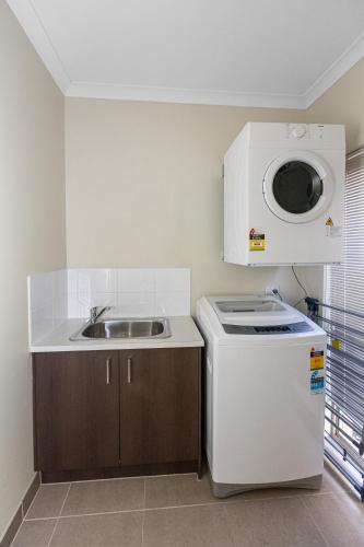 a small kitchen with a sink and a microwave at Spacious Villa 7BRM 5-bathroom House Point Cook Double Storey in Point Cook