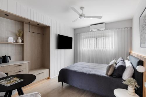 a bedroom with a bed and a table and a tv at The Lodge - 4 Luxury Central Private Studio Rooms - Free wifi in Mount Gambier