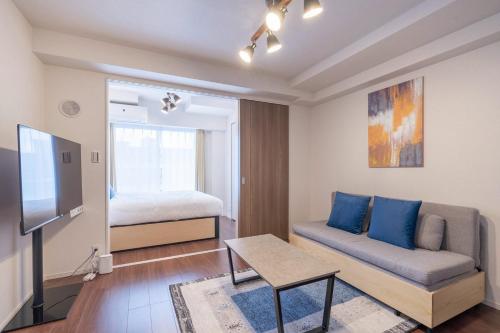 a living room with a couch and a bed at Art Nagara in Osaka
