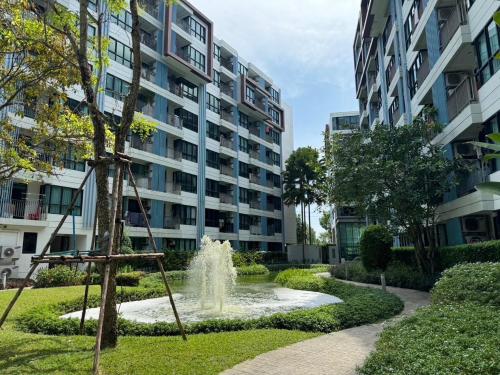 een fontein in een park voor een gebouw bij Centrio Condominiums Top Floor with Pool and Garden view in Ban Na Khua