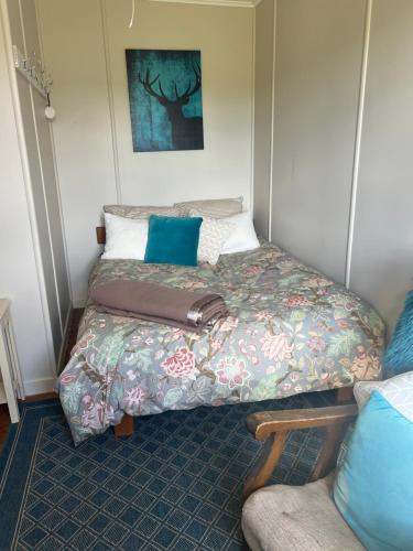 a bed in a small room with a suitcase on it at Pohokura Farmstay in Taihape