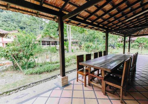una mesa de madera y sillas en un patio en Al Sakinah Resort en Bentong