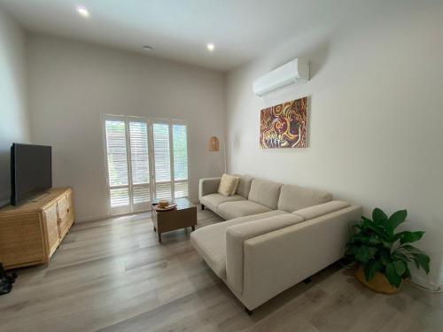 a living room with a couch and a tv at Charming Beach Getaway in Valla Beach