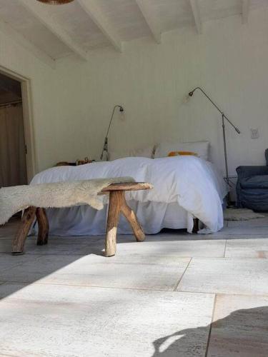 a bedroom with a bed and a wooden bench at Chacra en Cañuelas in Cañuelas