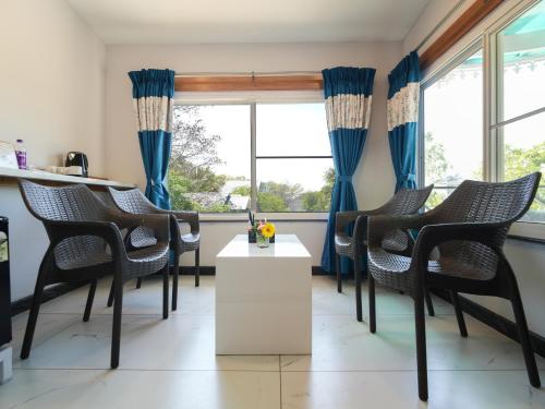 a room with chairs and a table and windows at MGM Whispering Wind's Yelagiri in Yelagiri