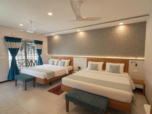 a hotel room with two beds and a window at MGM Whispering Wind's Yelagiri in Yelagiri