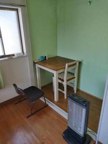 a small room with a table and a chair and a television at 川っぺり　大出 in Kujukuri