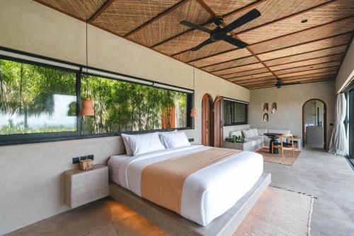 a bedroom with a bed and a large window at SIVANA, Hotel Boutique with ocean or garden views - Adults only in Uluwatu