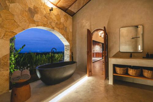 a bathroom with a large tub with a view of the ocean at SIVANA, Hotel Boutique with ocean or garden views - Adults only in Uluwatu