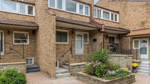 a brick house with stairs and flowers in front of it at Cozy Town house in Toronto