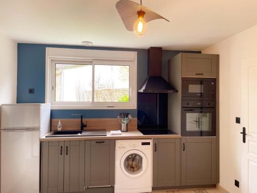une cuisine avec une machine à laver et une fenêtre dans l'établissement Gîte tout inclus à proximité de Beauval, 2 chambres, jardin, terrasse privée, animaux acceptés - FR-1-491-337, à Couffy