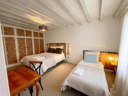 una camera con due letti e un tavolo di Gîte tout inclus à proximité de Beauval, 2 chambres, jardin, terrasse privée, animaux acceptés - FR-1-491-337 a Couffy