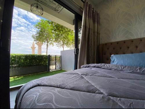 a bedroom with a bed and a large window at Orak Villa Homestay at Suria Residence in Shah Alam