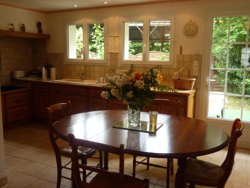 une cuisine avec une table avec un vase de fleurs dessus dans l'établissement Maison à Cheverny, 6 pers, jardin, proche château, animaux acceptés, internet, parking privé. - FR-1-491-338, à Cheverny
