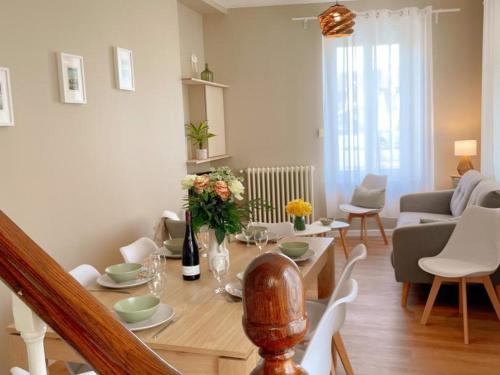 - un salon avec une table à manger fleurie dans l'établissement Gîte tout confort pour 6-8 pers, cœur de village, parking privé, jardin clos, proche ZooParc de Beauval - FR-1-491-344, à Noyers-sur-Cher