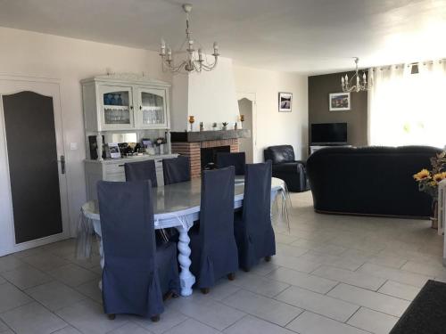 une salle à manger et un salon avec une table et des chaises dans l'établissement Gîte familial en Sologne : jardin, équipements enfants, vélos, proche Châteaux de la Loire - FR-1-491-348, à Dhuizon