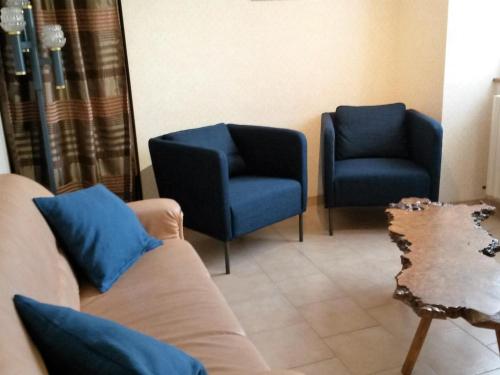 sala de estar con 2 sillas azules y sofá en Gîte Maslives, 3 pièces, 5 personnes - FR-1-491-352, en Maslives