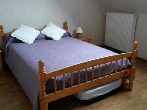 1 dormitorio con 1 cama de madera y 2 almohadas en Gîte Maslives, 3 pièces, 5 personnes - FR-1-491-352, en Maslives