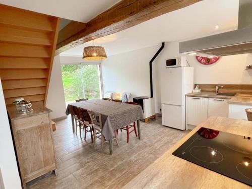 une cuisine et une salle à manger avec une table et un réfrigérateur dans l'établissement Gîte tout confort près du Zoo de Beauval avec jardin, terrasses et équipements modernes - FR-1-491-356, à Noyers-sur-Cher