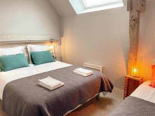 1 Schlafzimmer mit 2 Betten und Handtüchern auf dem Bett in der Unterkunft Gîte tout confort près du Zoo de Beauval avec jardin, terrasses et équipements modernes - FR-1-491-356 in Noyers-sur-Cher