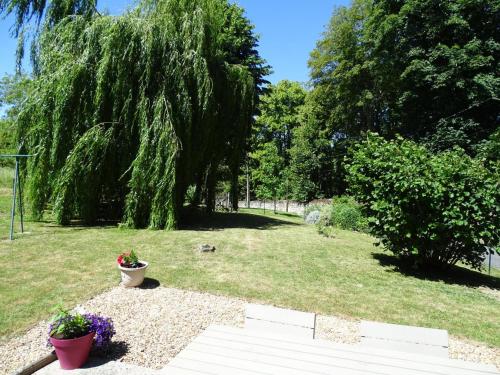 a garden with two potted plants and a tree at Longère paisible avec jardin, près châteaux de la Loire et Zoo de Beauval - FR-1-491-339 in Pouillé