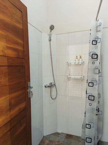 a bathroom with a shower with a glass door at Made Oka Homestay and Warung in Munduk