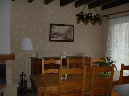 une salle à manger avec une table et des chaises en bois dans l'établissement Charmant gîte restauré, idéal famille, entre Vendôme et Lavardin, avec cheminée, jardin, et jeux enfants - FR-1-491-374, à Houssay