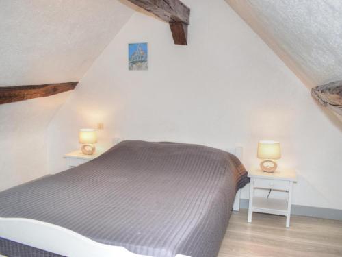 ein Schlafzimmer mit einem Bett und zwei Tischen mit Lampen in der Unterkunft Gîte Cour-Cheverny, 2 pièces, 2 personnes - FR-1-491-357 in Cour-Cheverny