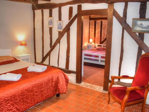 ein Schlafzimmer mit einem Bett und einem roten Stuhl in der Unterkunft Gîte Cour-Cheverny, 3 pièces, 5 personnes - FR-1-491-345 in Cour-Cheverny