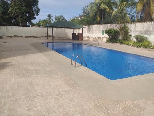 a swimming pool with a gazebo in a yard at Apartamento equipado frente de la bahía de pampatar in Pampatar