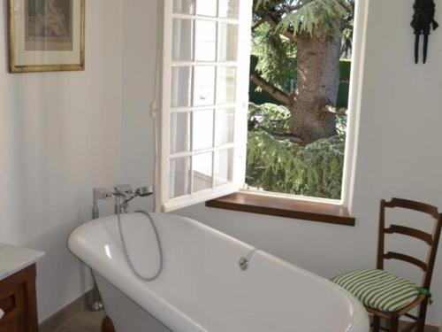 une baignoire dans une salle de bain avec une fenêtre dans l'établissement Luxueuse demeure rénovée avec piscine chauffée et vaste parc, à proximité des châteaux et du zoo de Beauval - FR-1-491-347, à Saint-Georges-sur-Cher