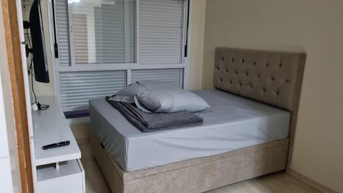 Una cama con una almohada en una habitación en Kitnet en Caxias do Sul