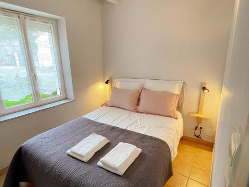 una camera da letto con un letto con due asciugamani sopra di Gîte confort pour 2 avec jardin privatif près des châteaux et du Zooparc de Beauval - FR-1-491-368 a Couffy