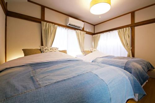a bedroom with two beds and a window at -Takaya house- Minamirokugou close Haneda AP in Tokyo