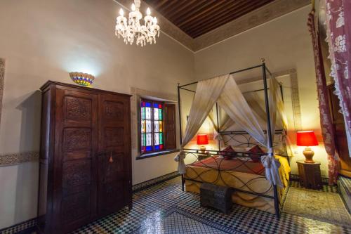 a bedroom with a bed and a chandelier at Riad Norma in Fès