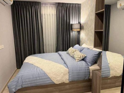 曼谷的住宿－SLPsD House，一间卧室配有一张带蓝色枕头的大床