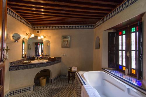 a large bathroom with a tub and a sink at Riad Norma in Fès