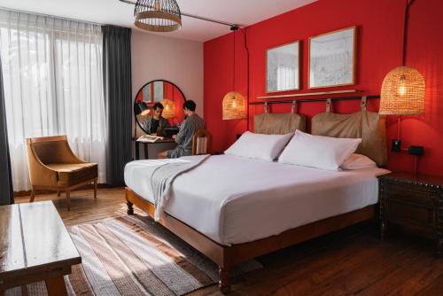 a bedroom with a large bed with a red wall at Selina Arequipa in Arequipa
