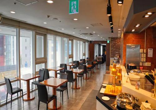 a restaurant with a row of tables and chairs at Haeundae Seacloud Hotel Residence in Busan