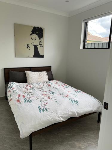 a bedroom with a bed with a floral bedspread at Little house with private garden in Padstow