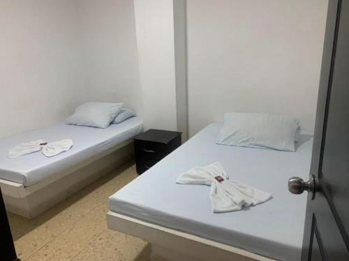 Dos camas en una habitación con toallas. en Hotel La Fresa L&G, en Pereira