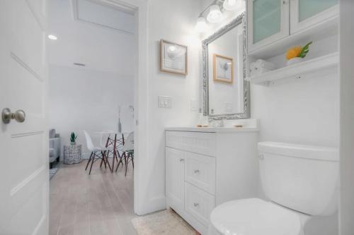 een witte badkamer met een wastafel en een spiegel bij Beachside Suite, Newly Renovated, Steps to the Sand, Relax and Unwind! in St. Augustine