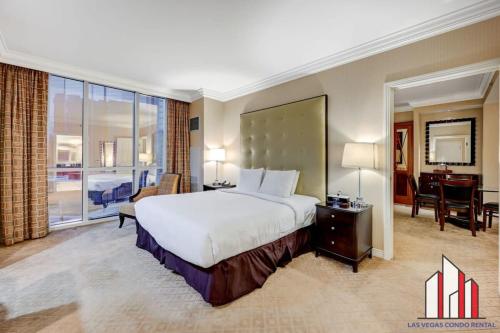 una camera d'albergo con un grande letto e una scrivania di MGM Signature-08-801 1Br2Ba F1 Strip View Balcony a Las Vegas