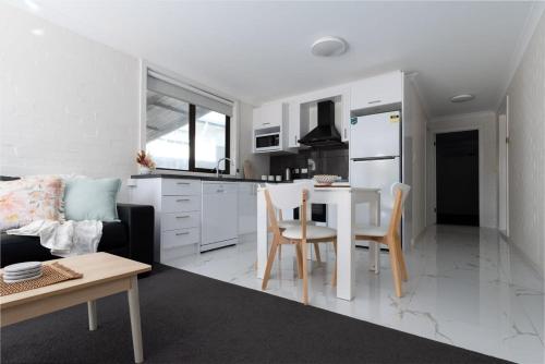 a kitchen and a living room with a table and chairs at Riverside Gem with Parking and WiFi in Alanvale
