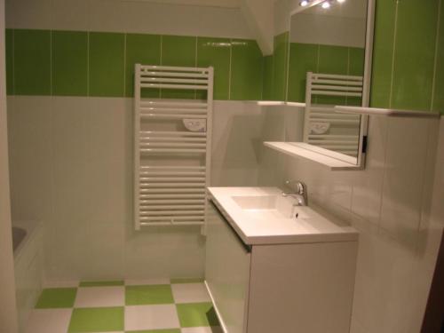 a green and white bathroom with a sink and mirror at Gîte Moderne avec Piscine Chauffée entre Blois et Vendôme, Idéal Familles, Animaux Acceptés - FR-1-491-377 in Averdon