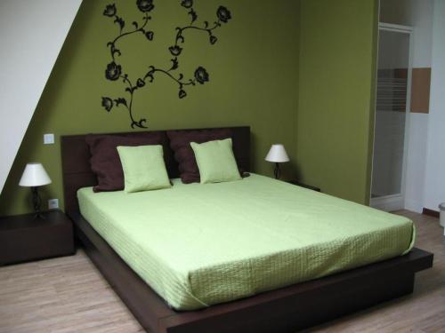 a bedroom with a bed with a green wall at Gîte Moderne avec Piscine Chauffée entre Blois et Vendôme, Idéal Familles, Animaux Acceptés - FR-1-491-377 in Averdon